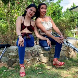 Megan & Via wearing jeans and sharing one pair of red heels